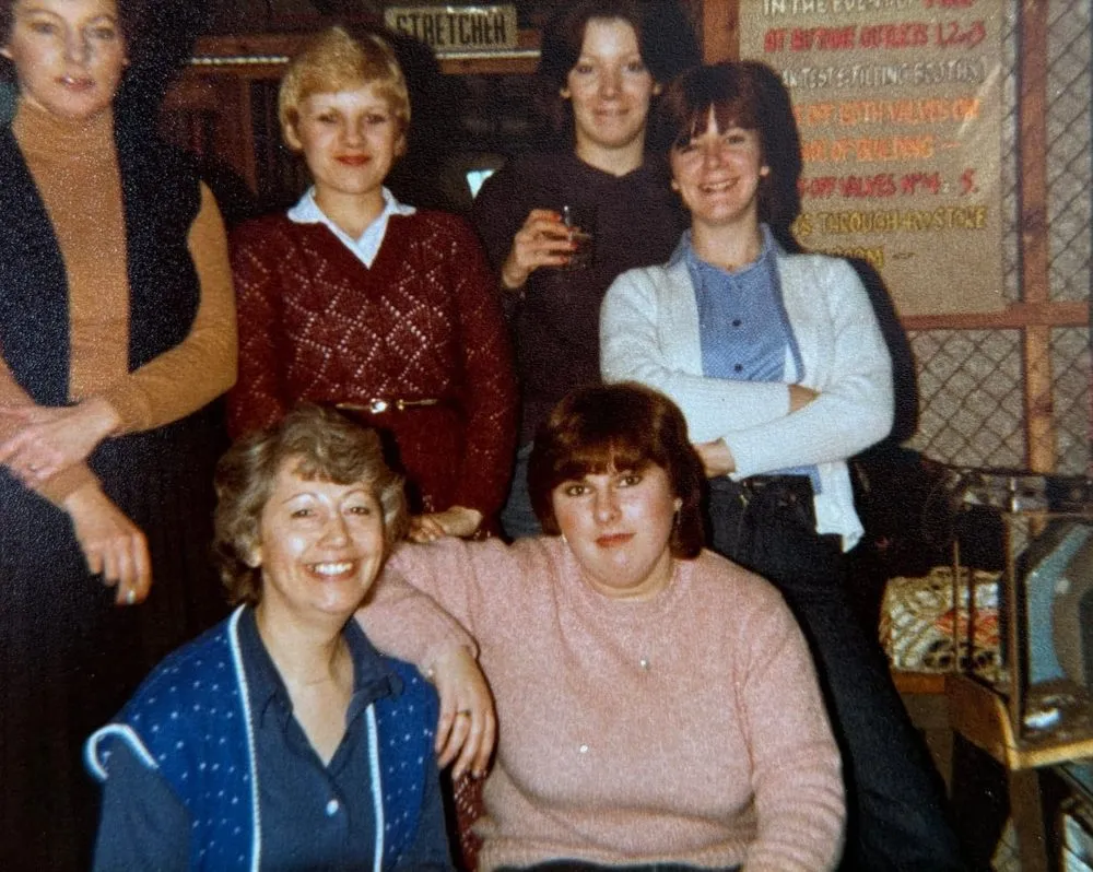 Colour photograph of six women from the factory smiling together at a Christmas celebration in 1980.